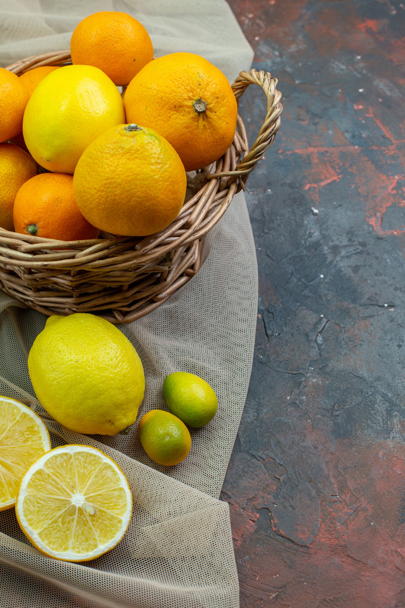 _bottom-view-fresh-mandarins-wicker-basket-cut-lemons-cumcuat-tulle-dark-red-ground orange 2